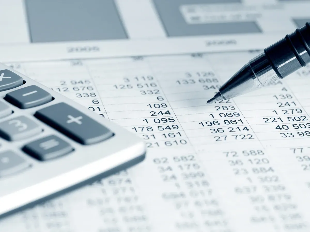 A financial statement with a calculator and pen.
