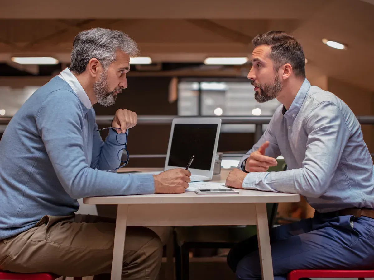 Two professionals having a serious discussion, symbolizing the process of selecting a financial advisor.