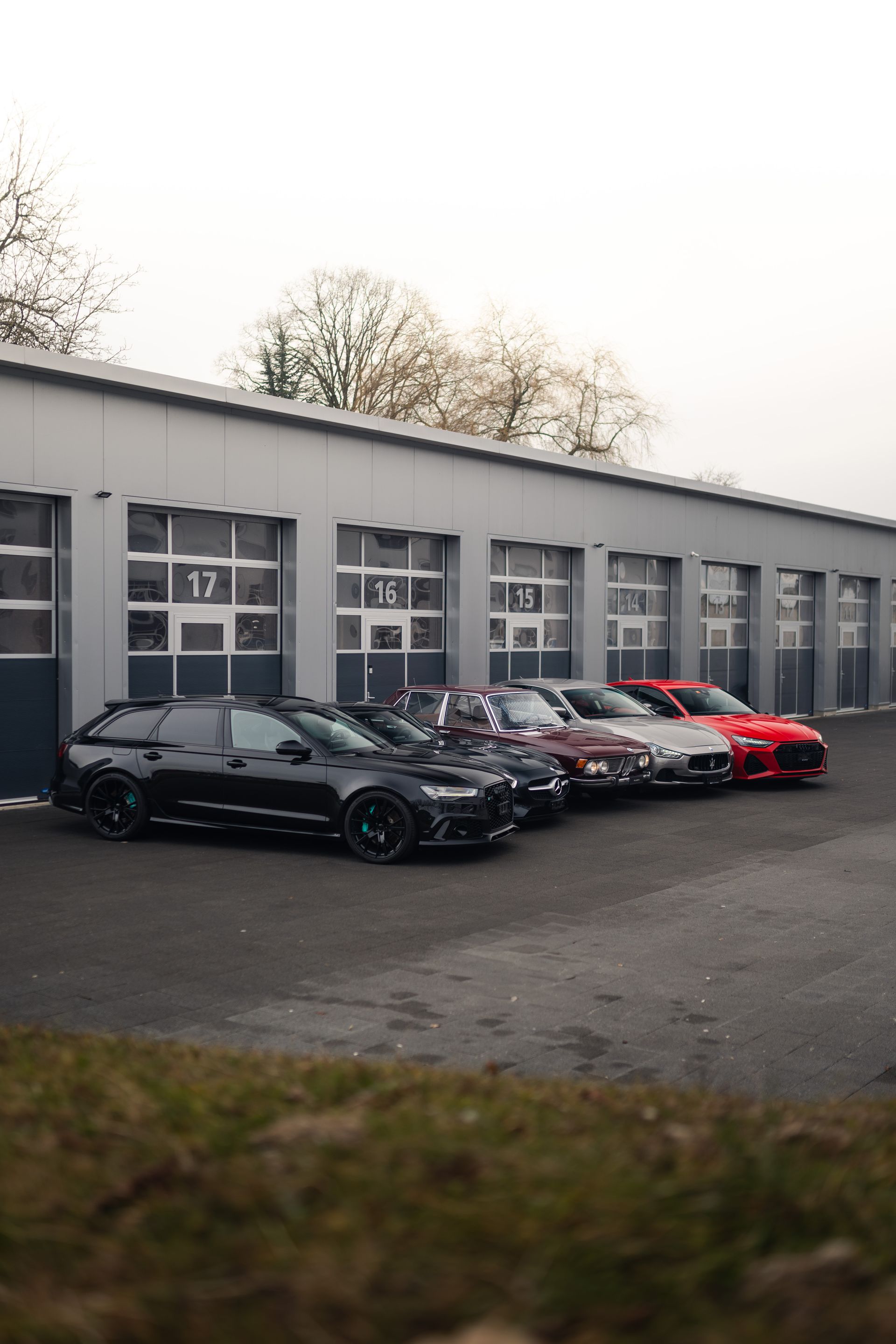 Vor einer Garage parken mehrere Autos.