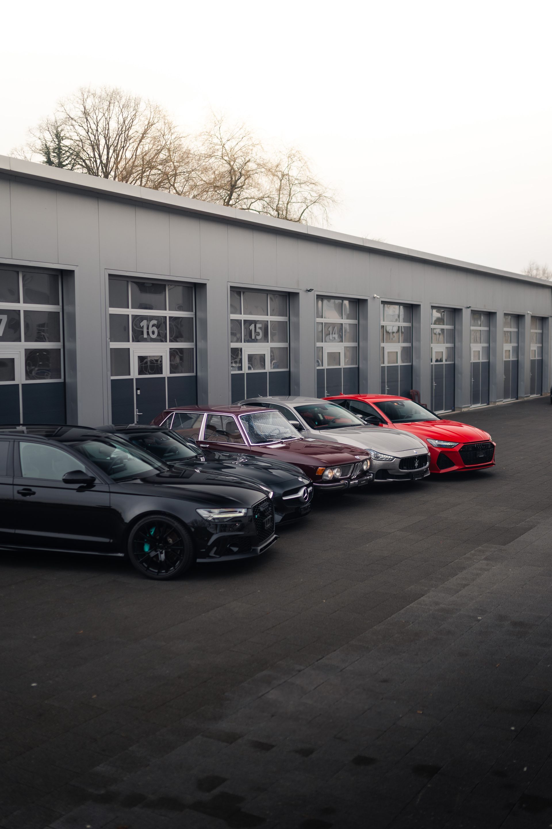 Vor einem Gebäude parkt eine Reihe von Autos.