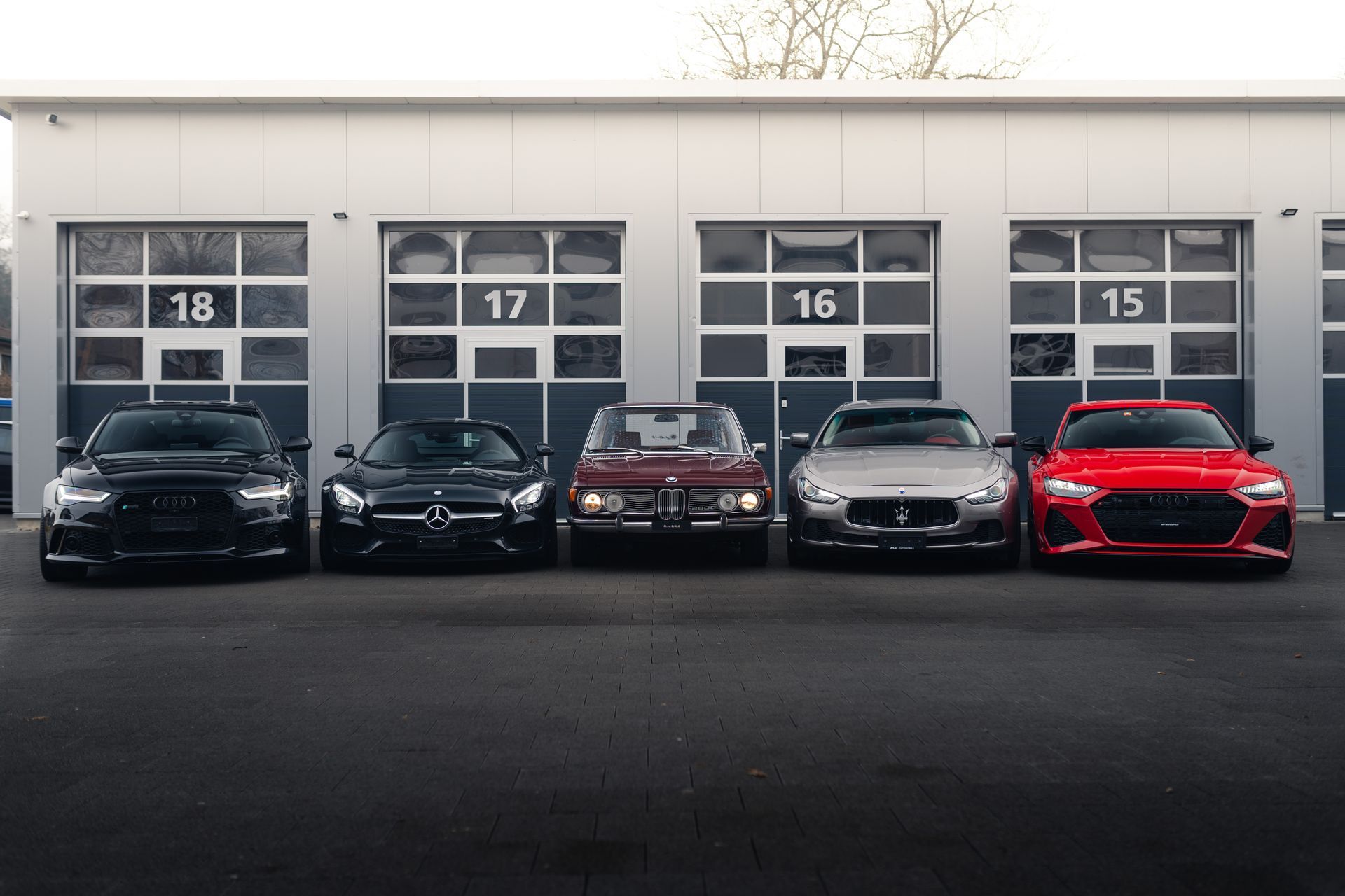 Vor einer Garage parken mehrere Autos.