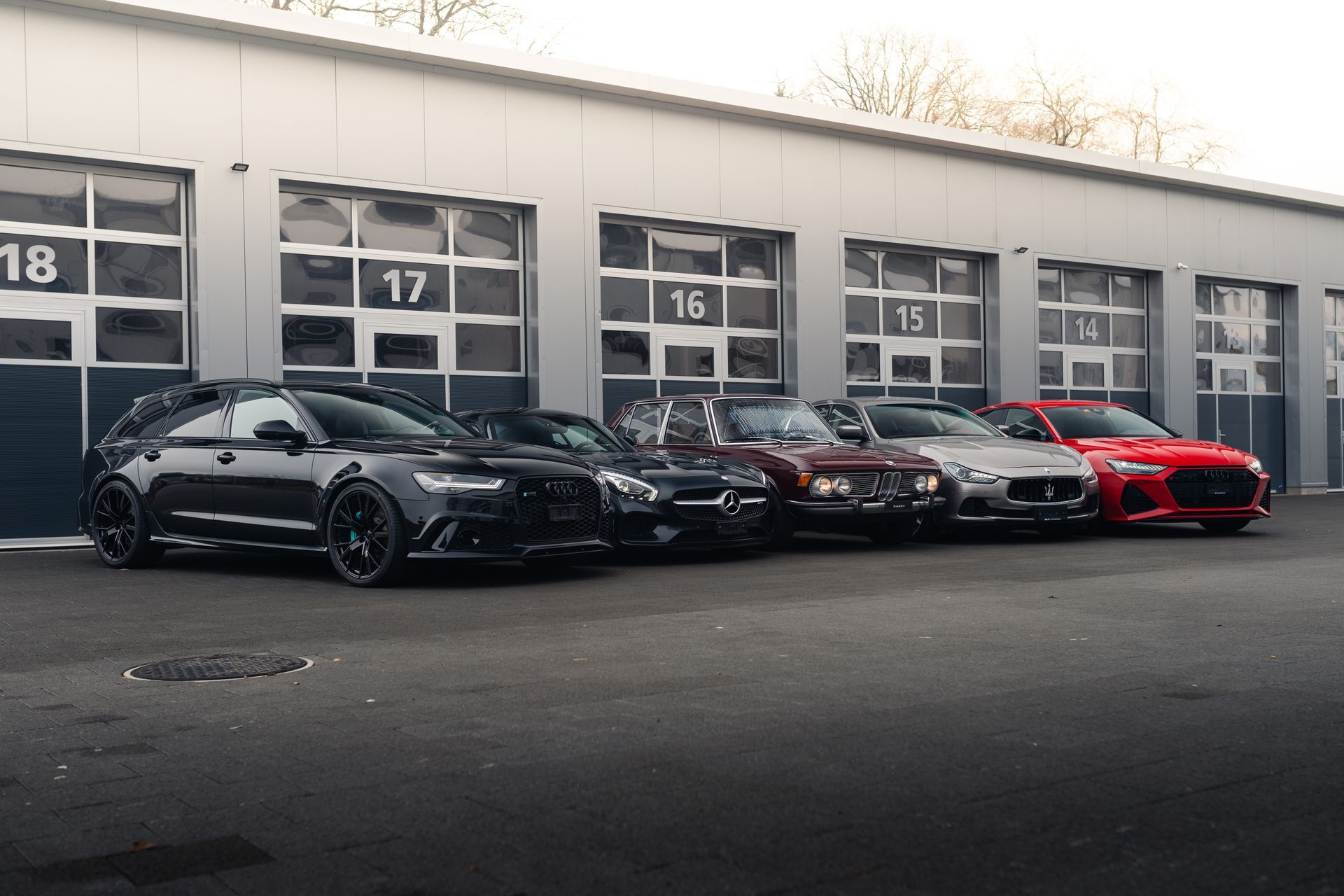 Vor einer Garage parken mehrere Autos.