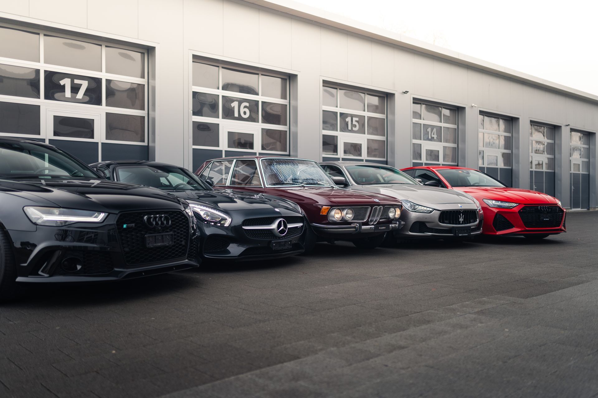 Vor einem Gebäude parkt eine Reihe von Autos.