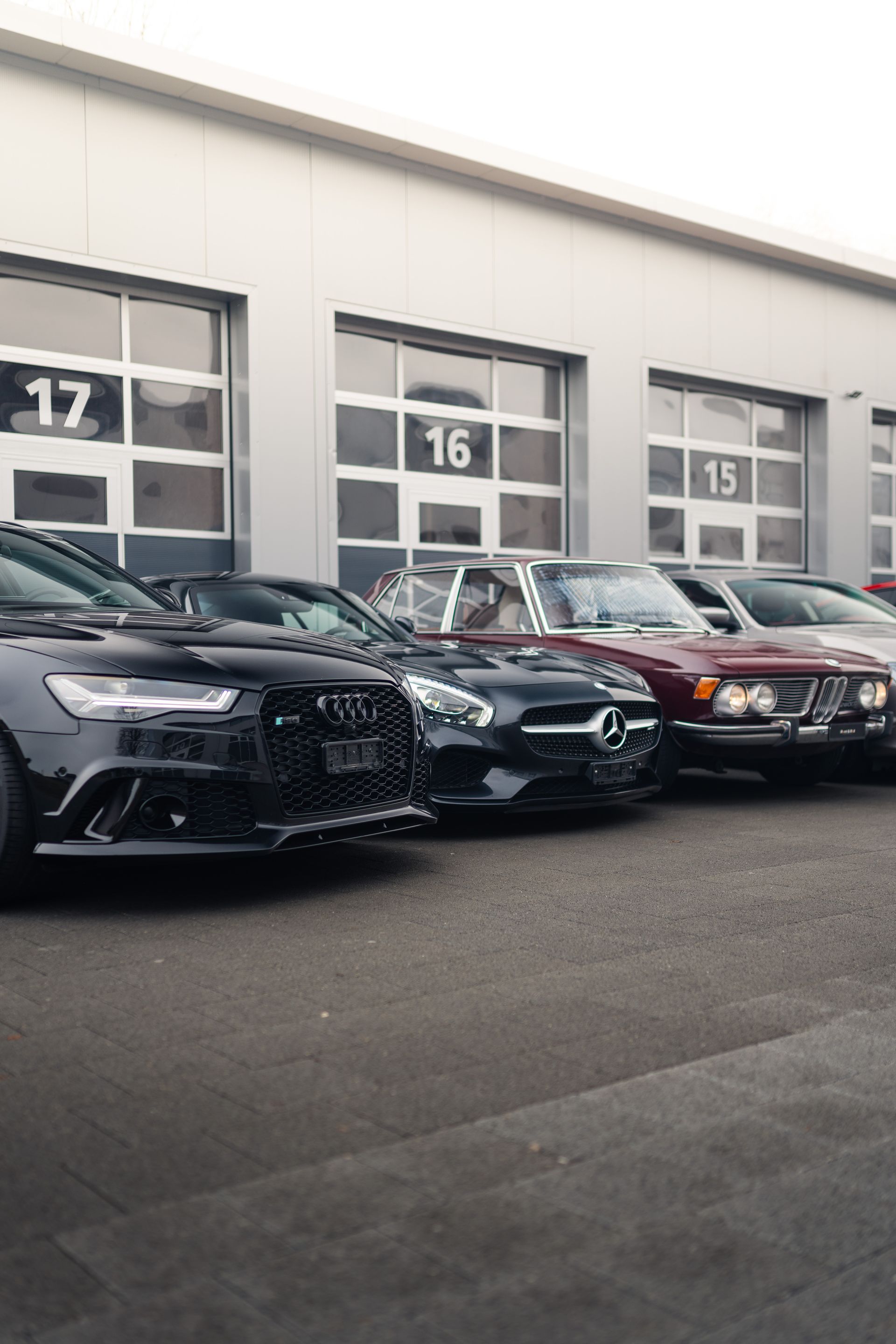 Vor einem Gebäude parkt eine Reihe von Autos.