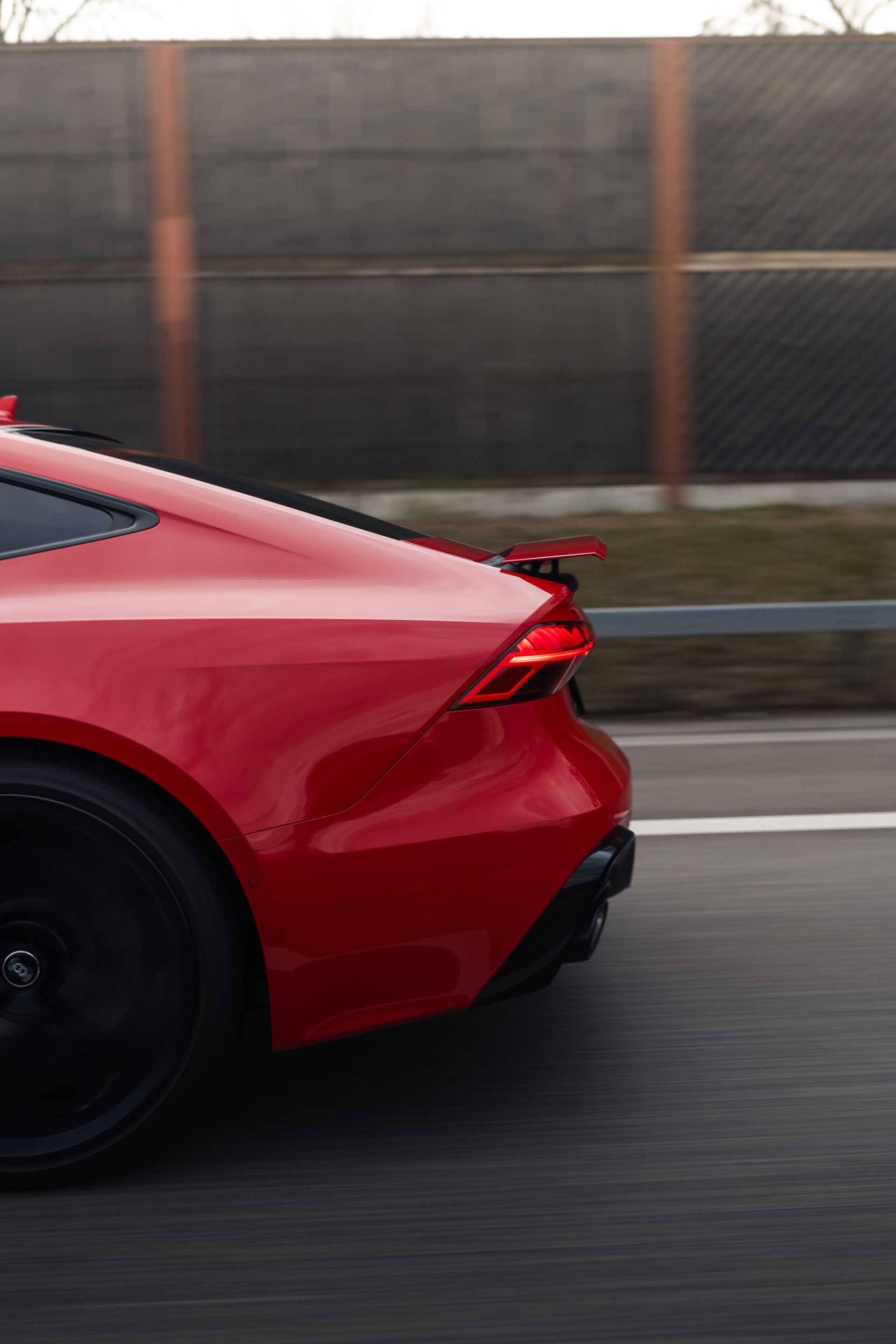 Ein roter Sportwagen fährt eine Autobahn entlang