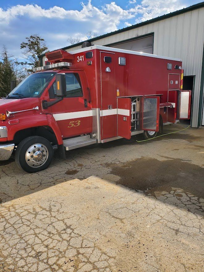 Red Ambulance Parking Outside  - Milton, NH  - RV Service and R & L Van Builds