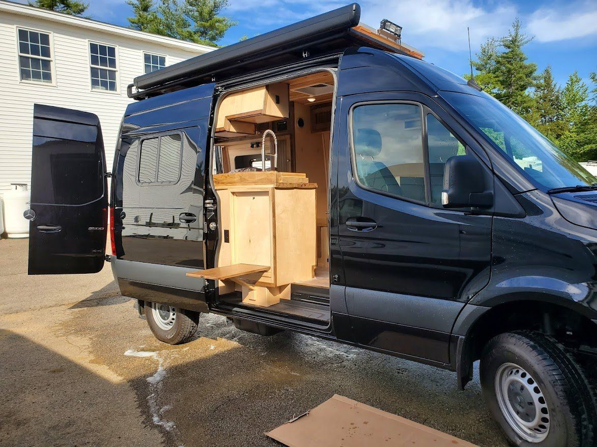 Black Camper Van While The Door Open - Milton, NH - RV Service and R & L Van Builds