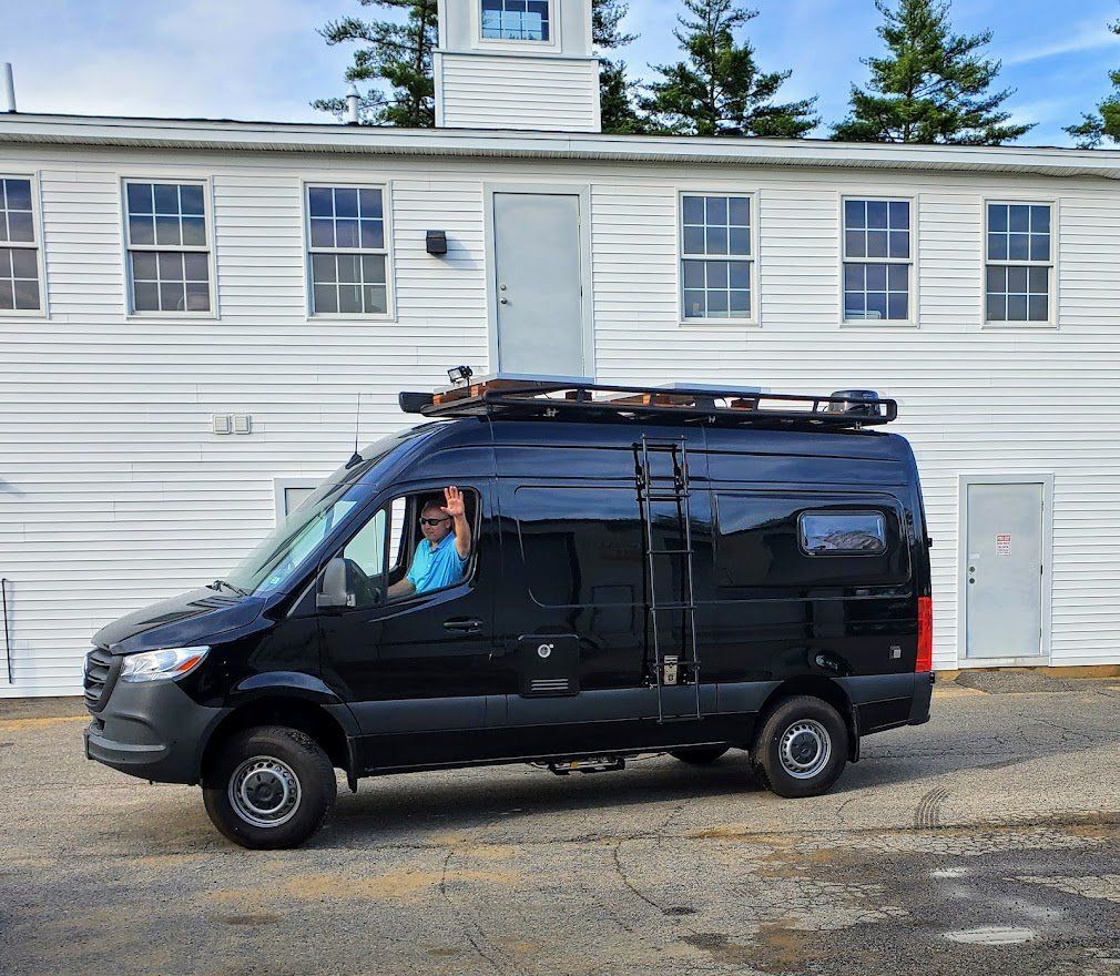 Black Camper Van Waving The Driver - Milton, NH - RV Service and R & L Van Builds