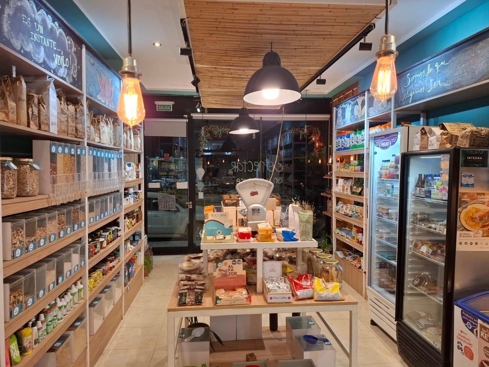 Interior de la tienda Carda & Momo: mostrador con productos, estantes de madera, letrero luminoso.