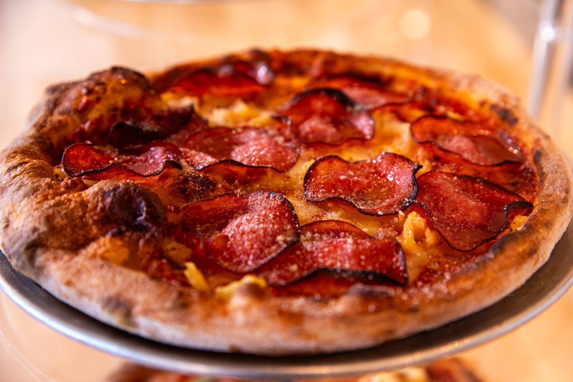 A pepperoni pizza is sitting on top of a metal pan.