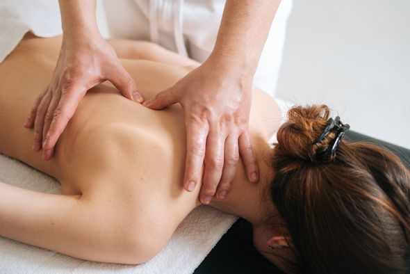 A woman is getting a massage on her back at a spa.