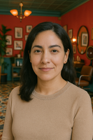A portrait of Kelly Ruiz wearing a coffee color full sleeve top, inside her hair salon.
