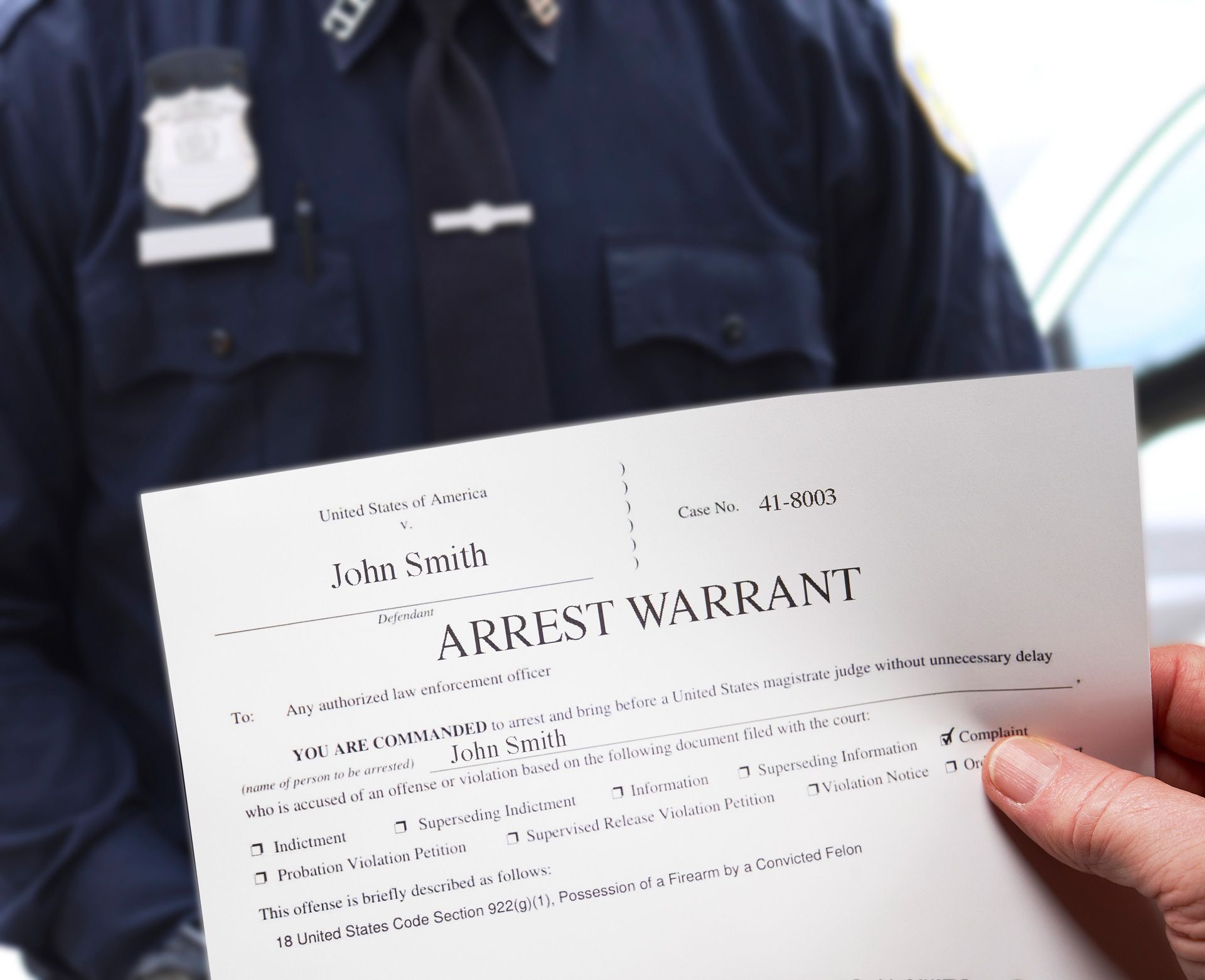 Arrest warrant with man holding warrant next to police officer.
