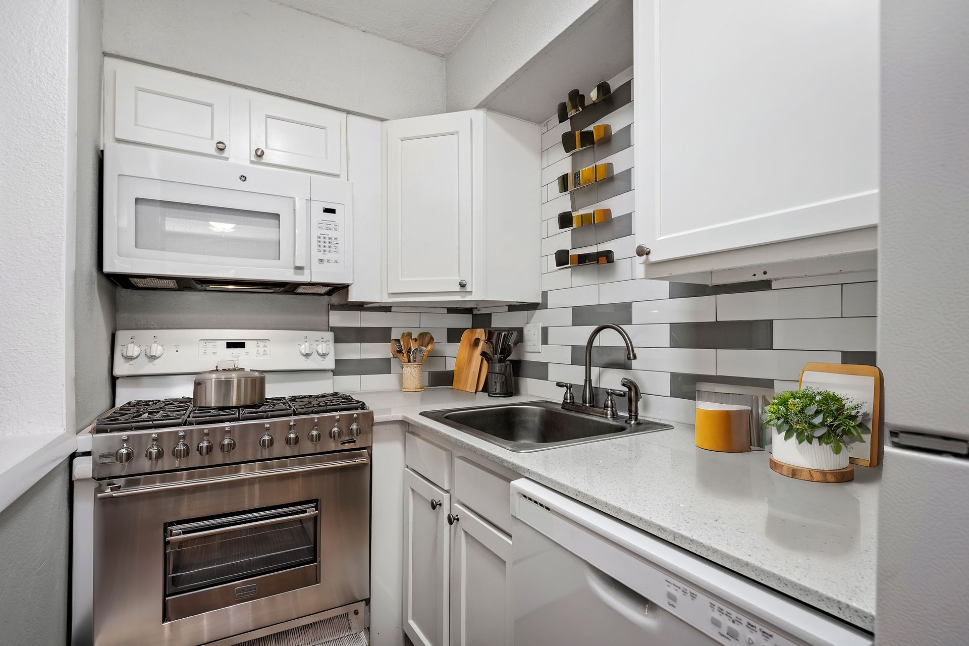 Photo of a kitchen with a stove, sink, microwave and cabinetry