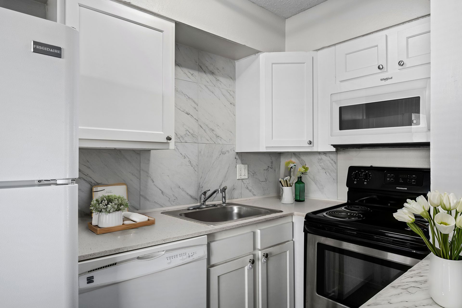 Photo of a kitchen with a dishwasher, refrigerator and a stove