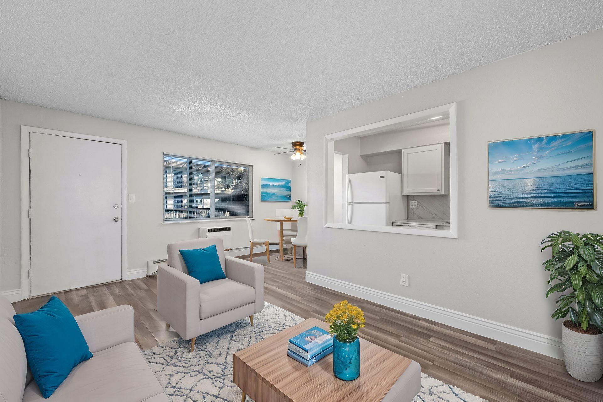 Photo of a living room with the kitchen in the background and a dining area nearby