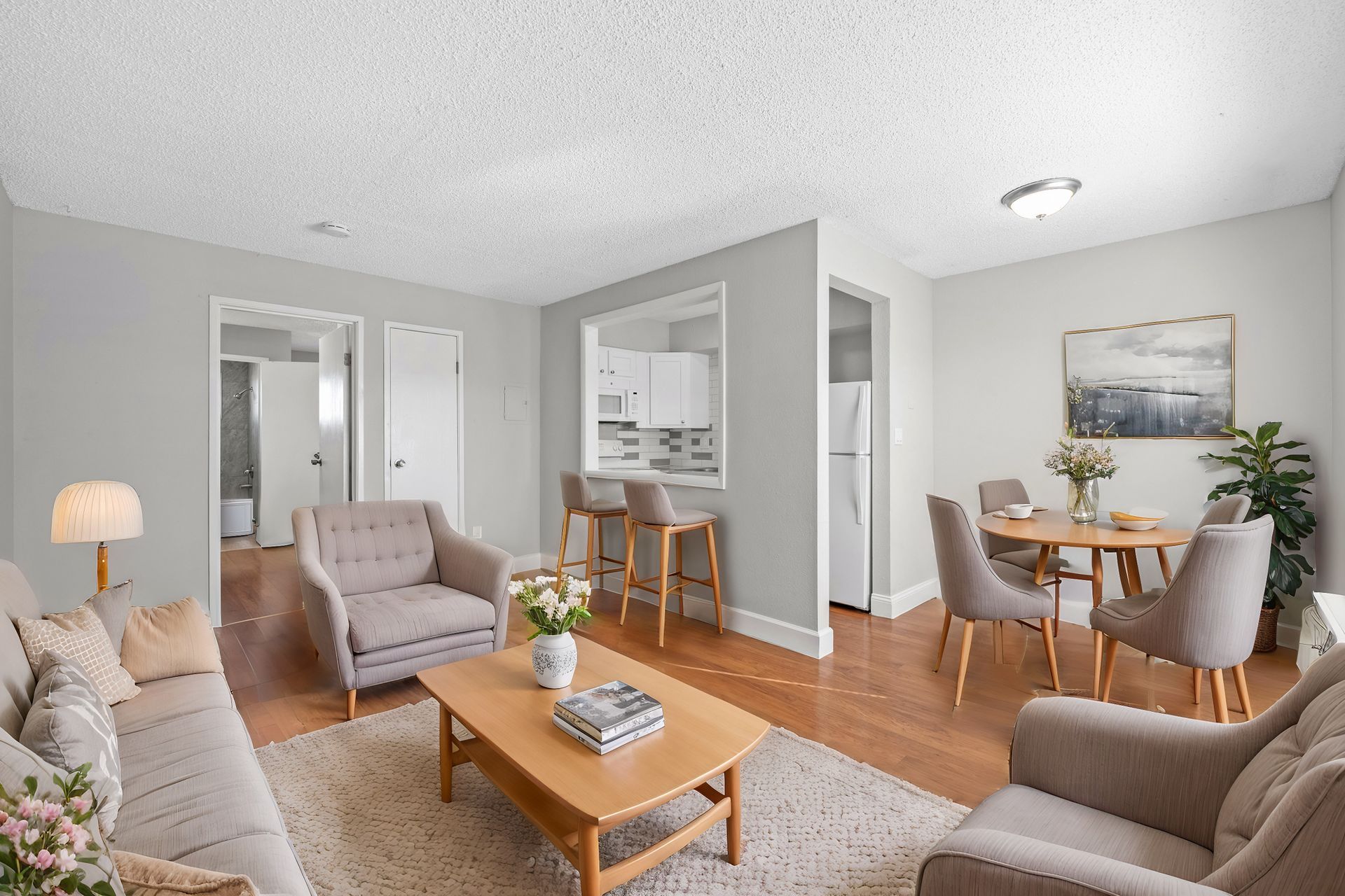 Photo of a living room with the kitchen, dining area and a bedroom in the background