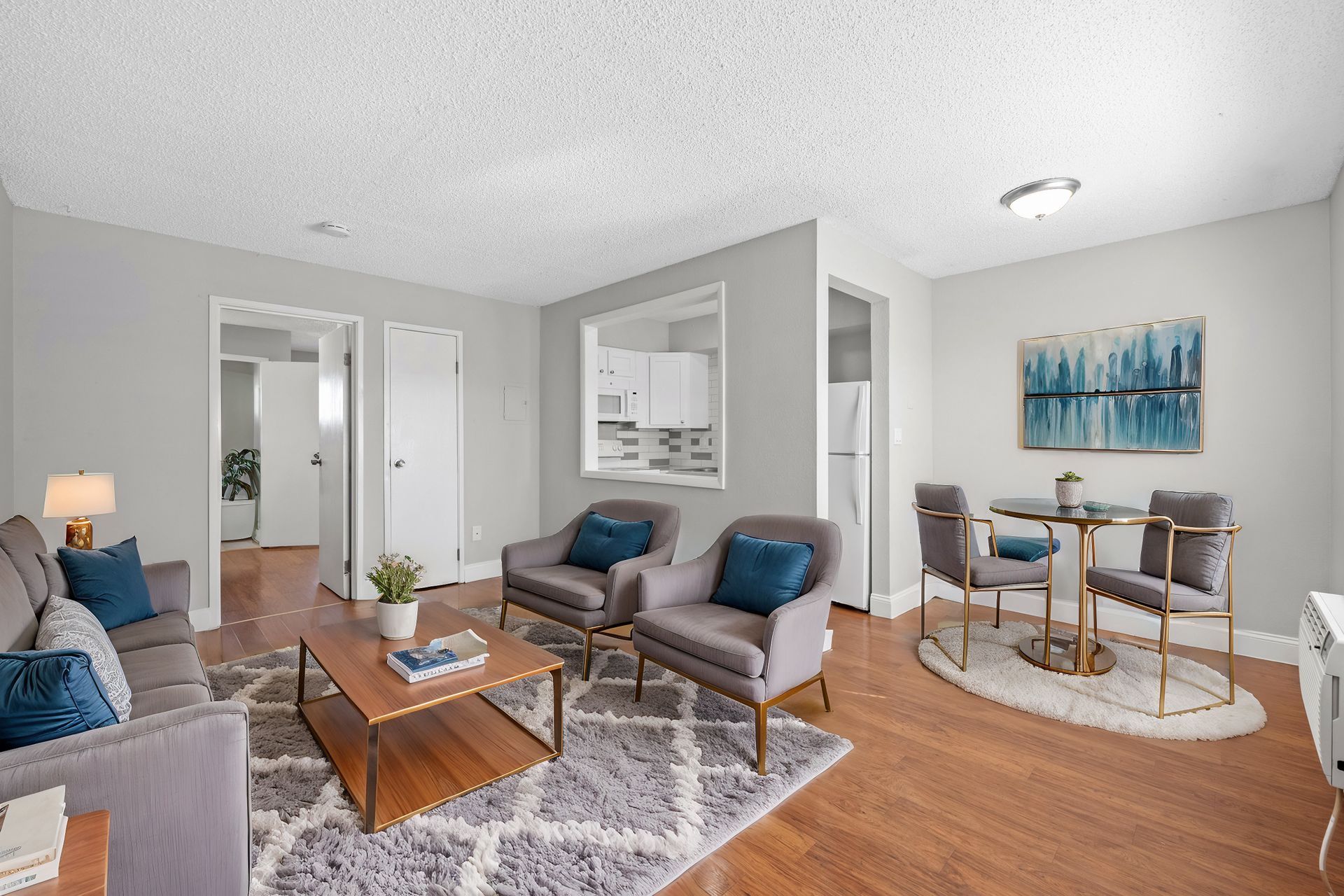 Photo of a living room with a kitchen in the background