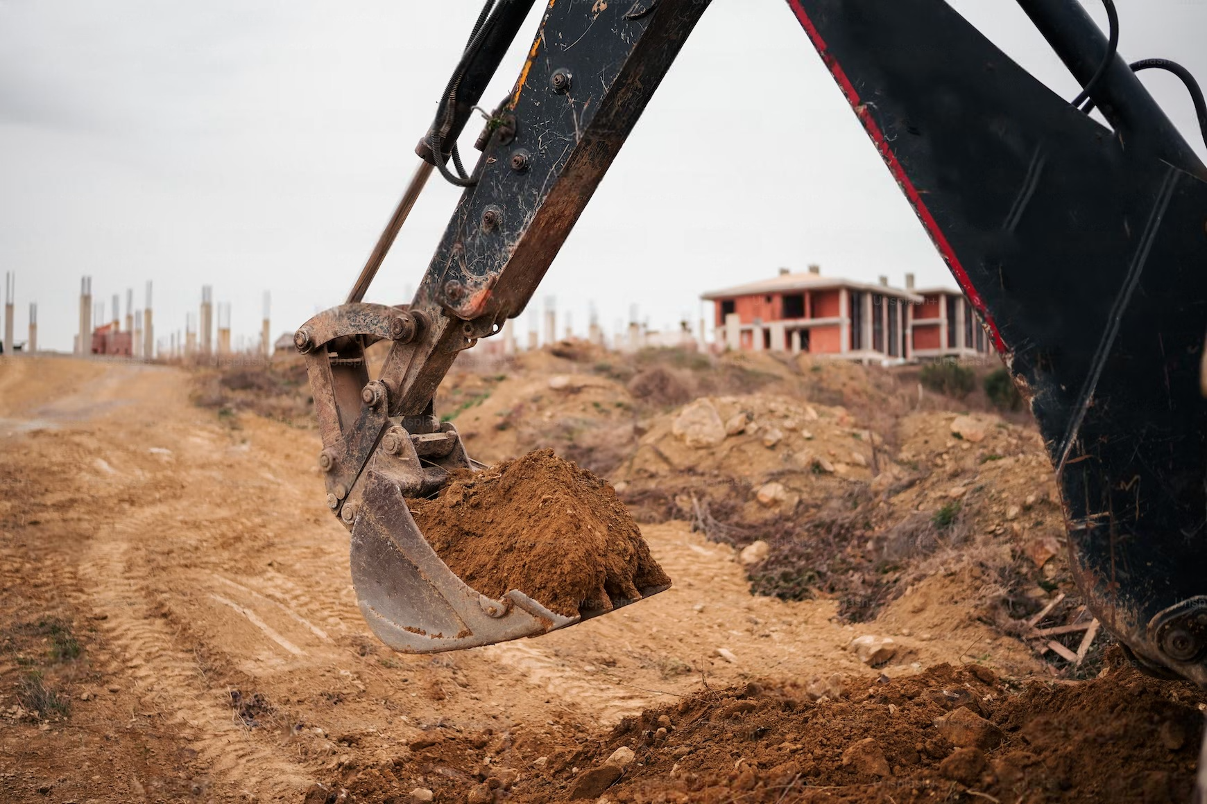 an excavator is digging a hole in the ground at a construction site .