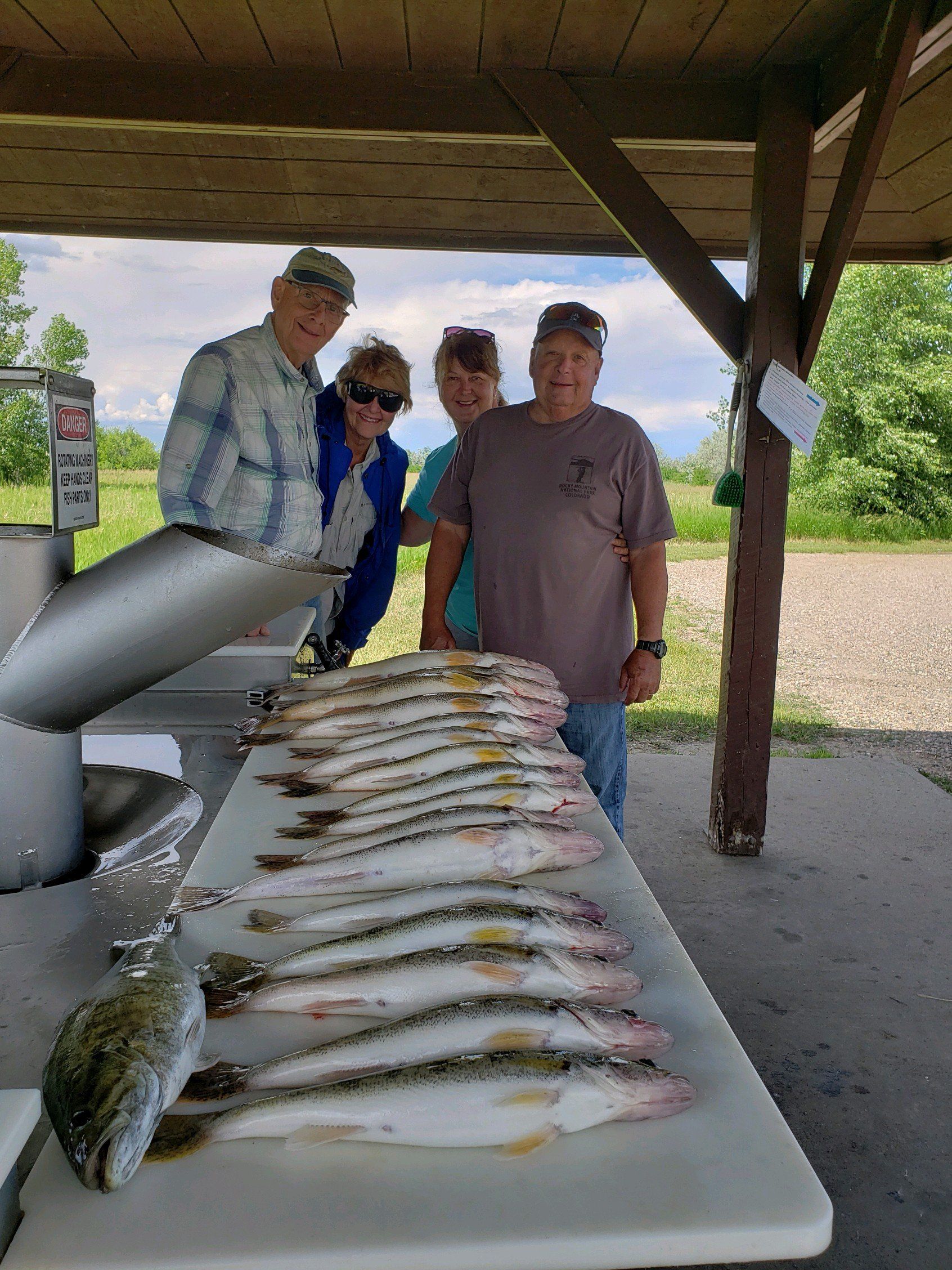 A group of people are standing around a table filled with fish.