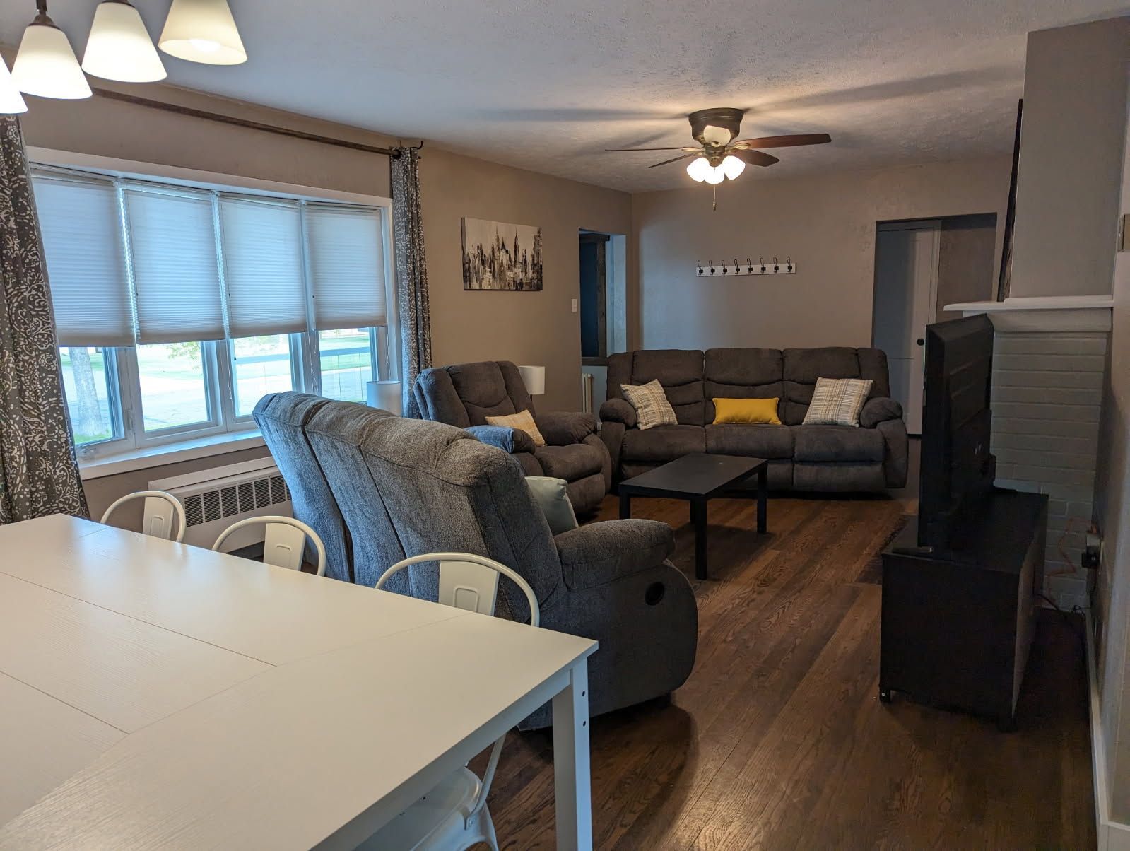 A living room with a couch , chair , table and television.