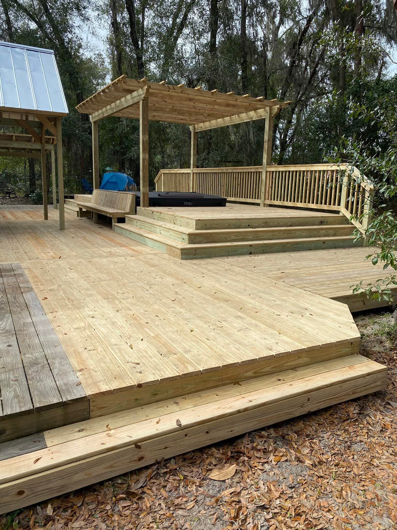 A wooden deck with stairs and a gazebo in the background.