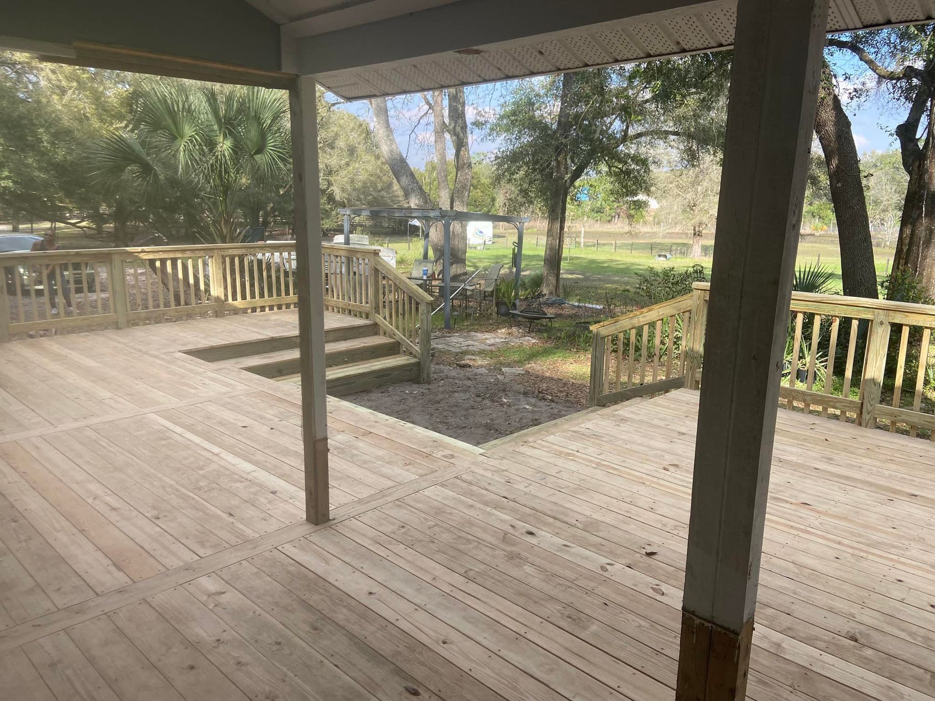 A large wooden deck with stairs leading up to it.