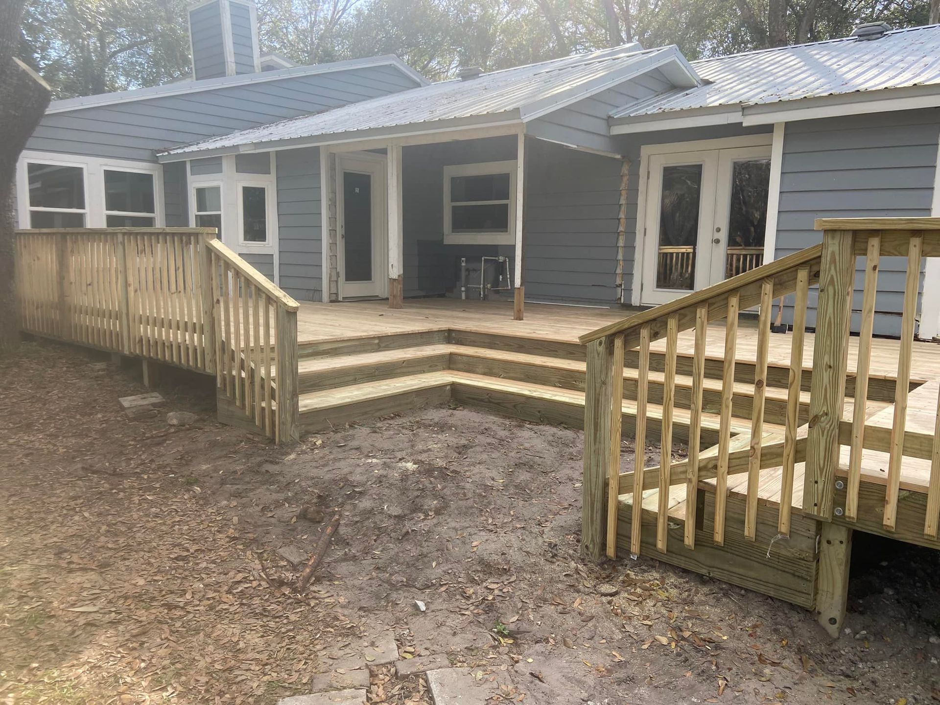 A house with a wooden deck and stairs in front of it.