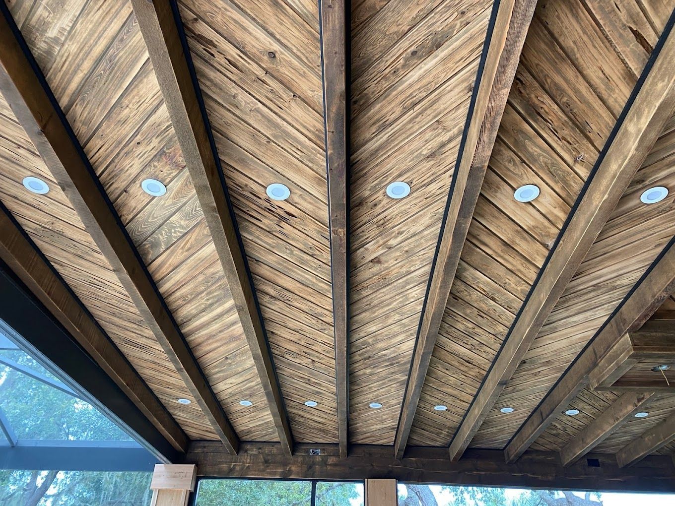 A wooden ceiling with a lot of beams and lights on it.