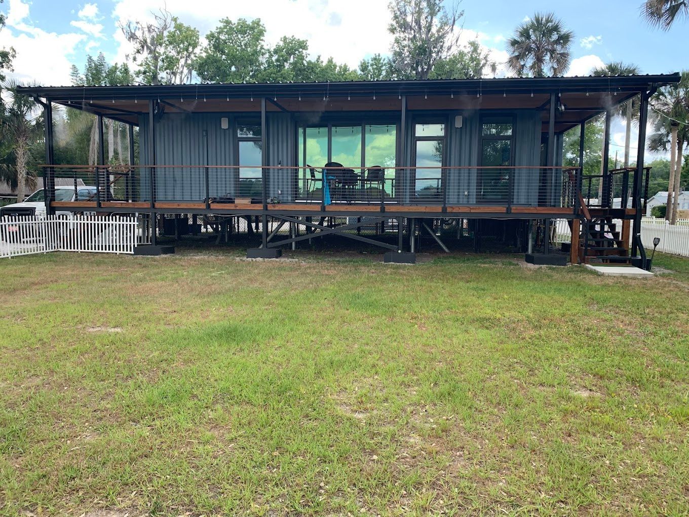 A large house is sitting on top of a lush green field.