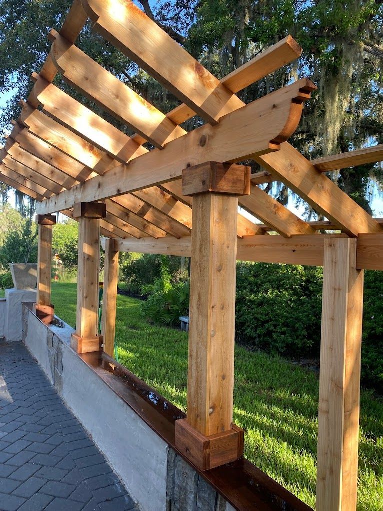 A wooden pergola is being built over a stone wall