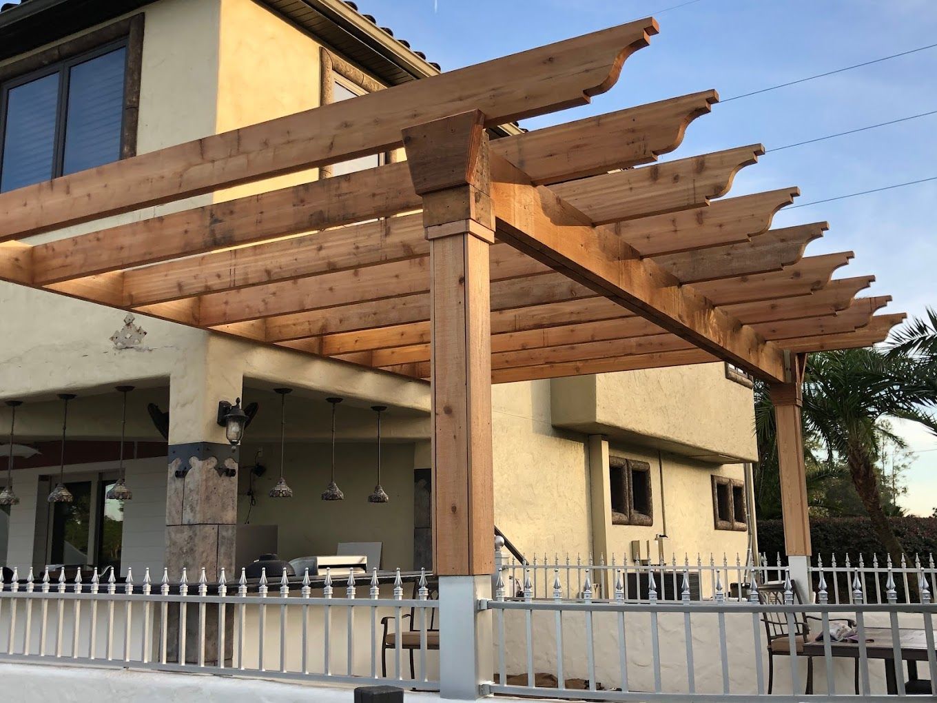A wooden pergola is sitting in front of a house.