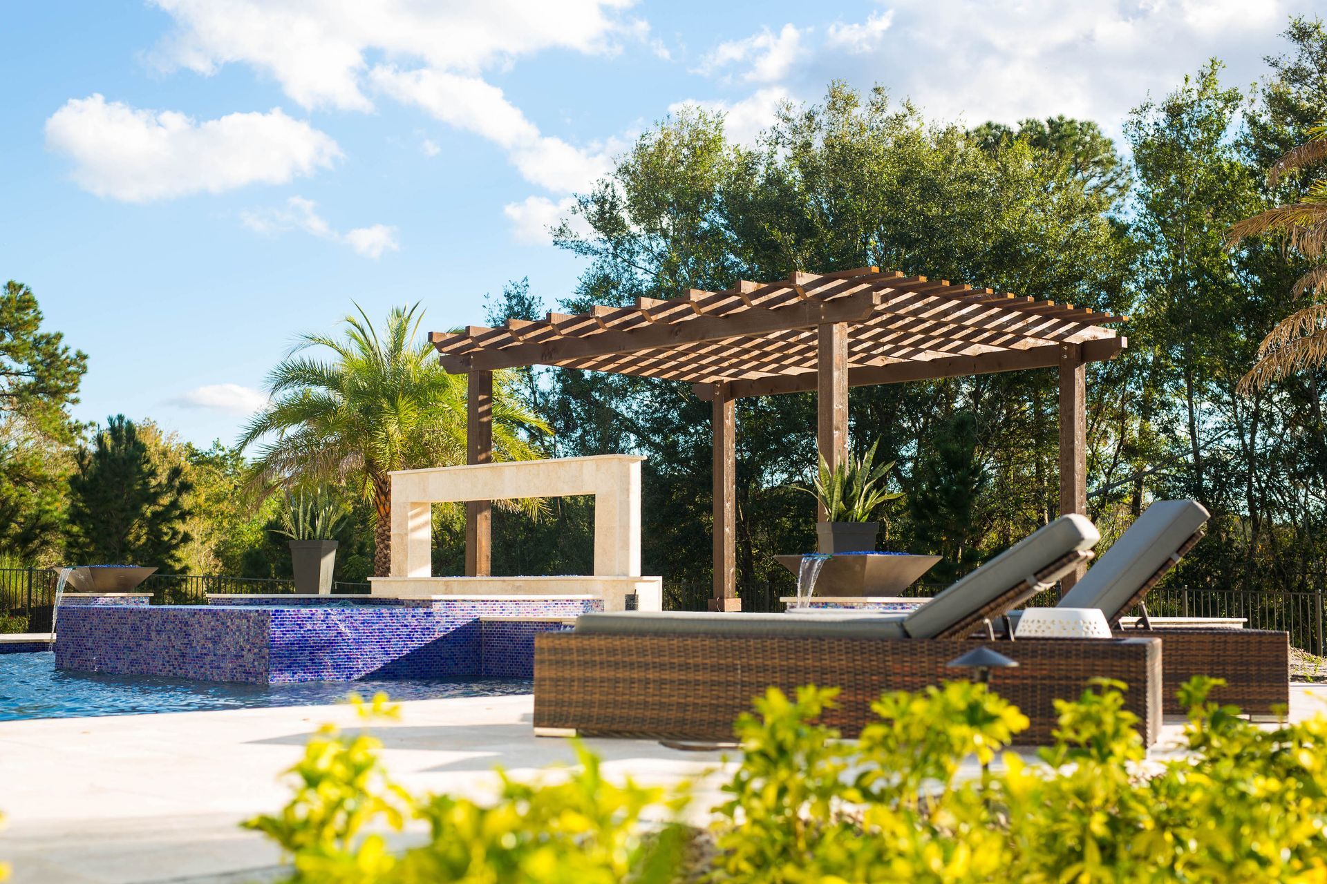 A swimming pool with a pergola and chairs around it