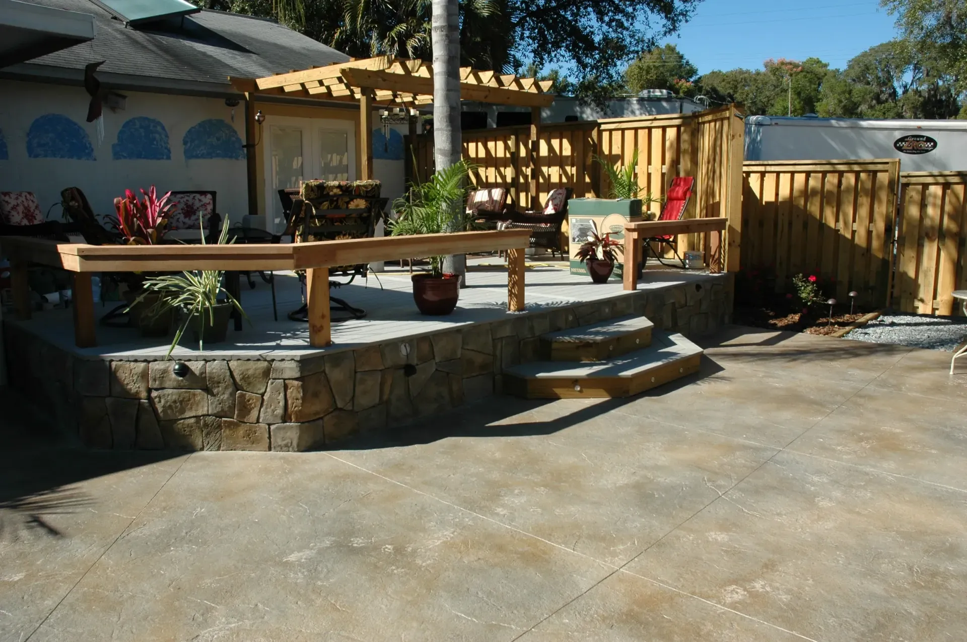A patio with a wooden railing and stairs leading up to it