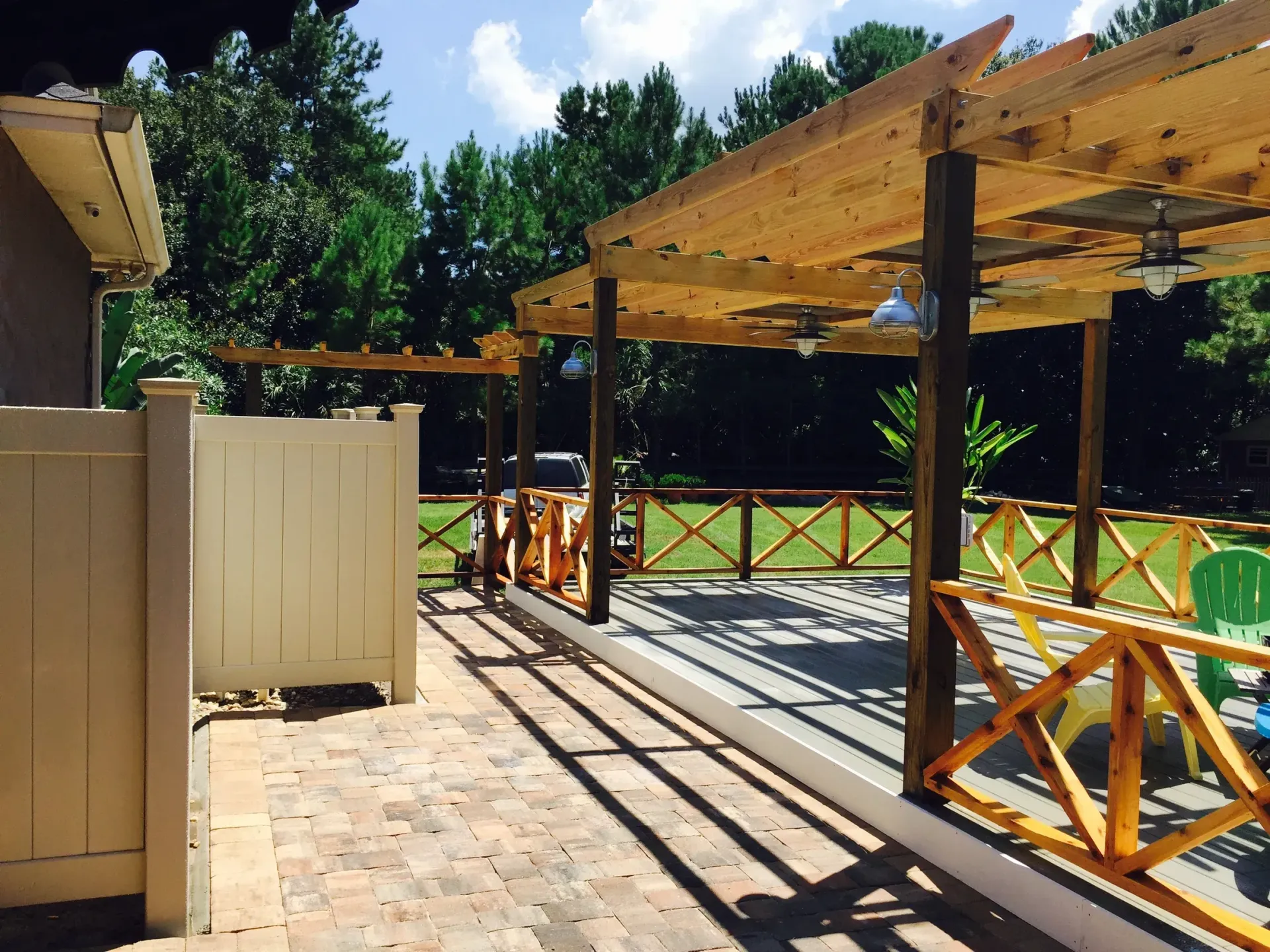 A patio with a pergola and a ceiling fan