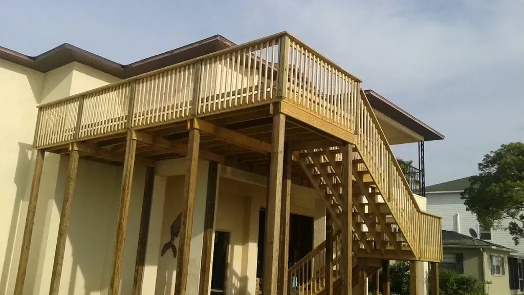 A house with a wooden deck and stairs leading up to it