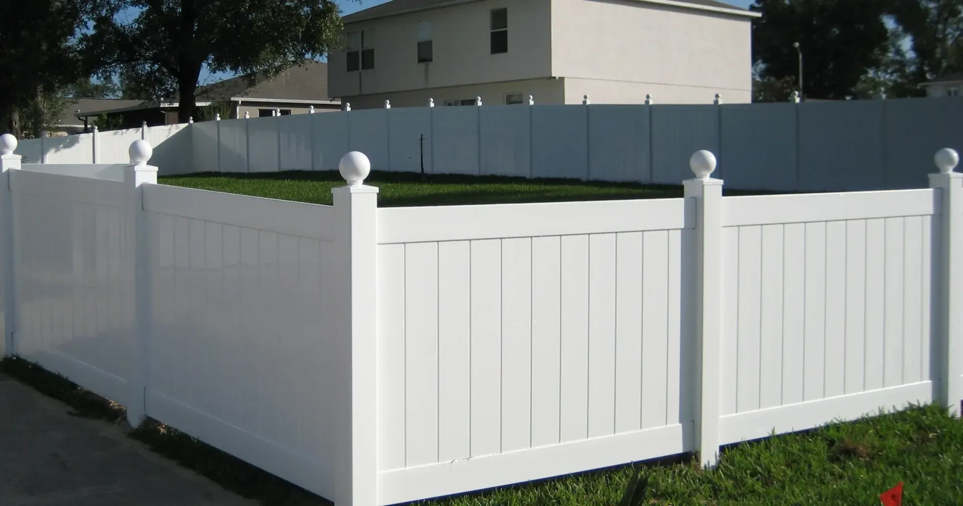 A white fence with a house in the background