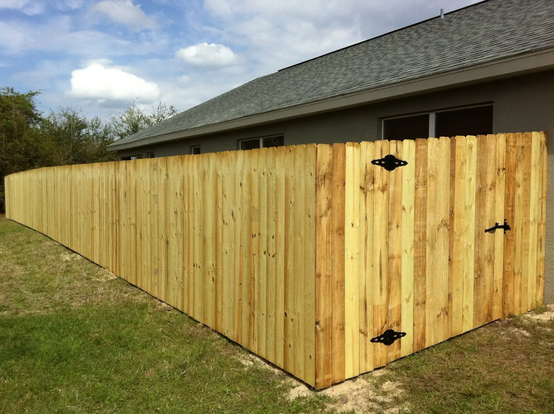 A wooden fence is sitting in front of a house.