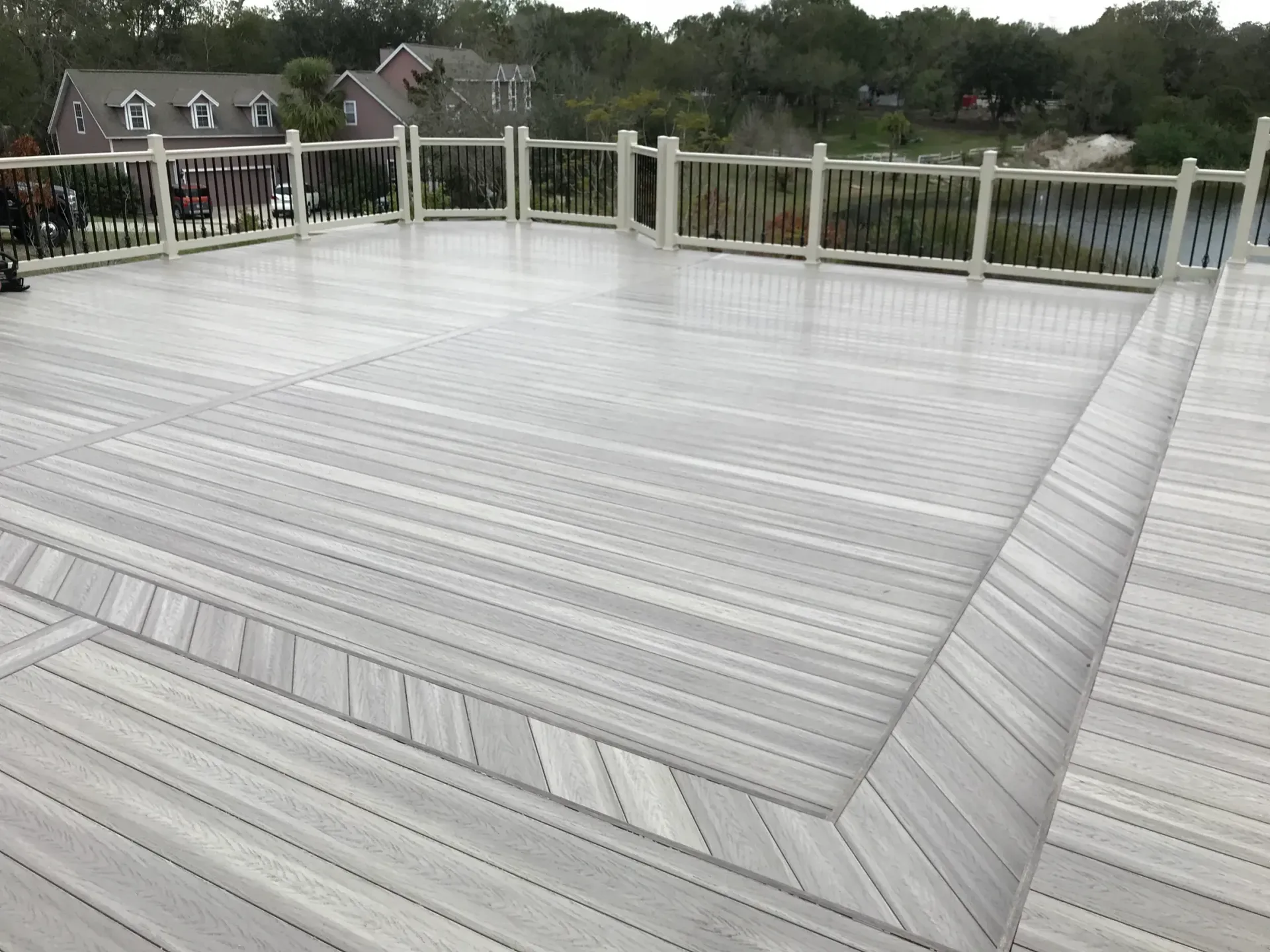 A large white wooden deck with a white railing