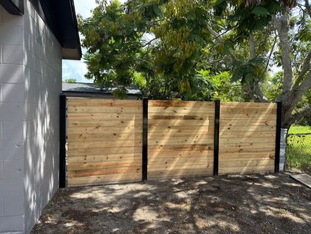 A wooden fence is sitting next to a house.