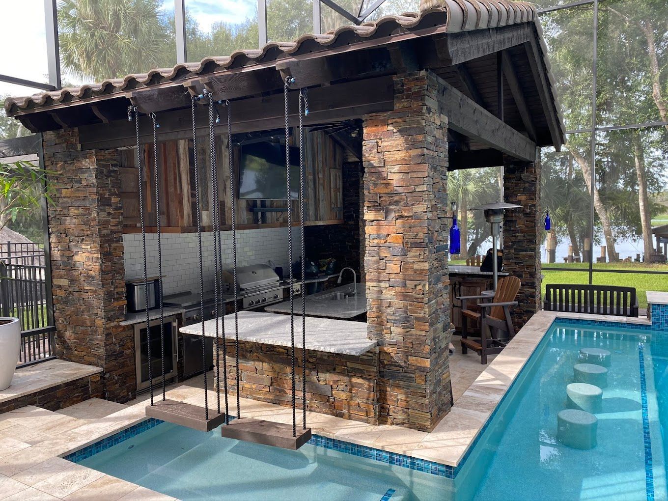 A swimming pool with a gazebo and swings next to it.
