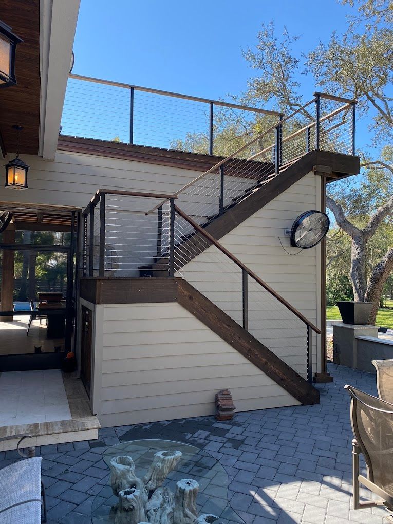 A wooden staircase leading up to a deck with a clock on the wall.