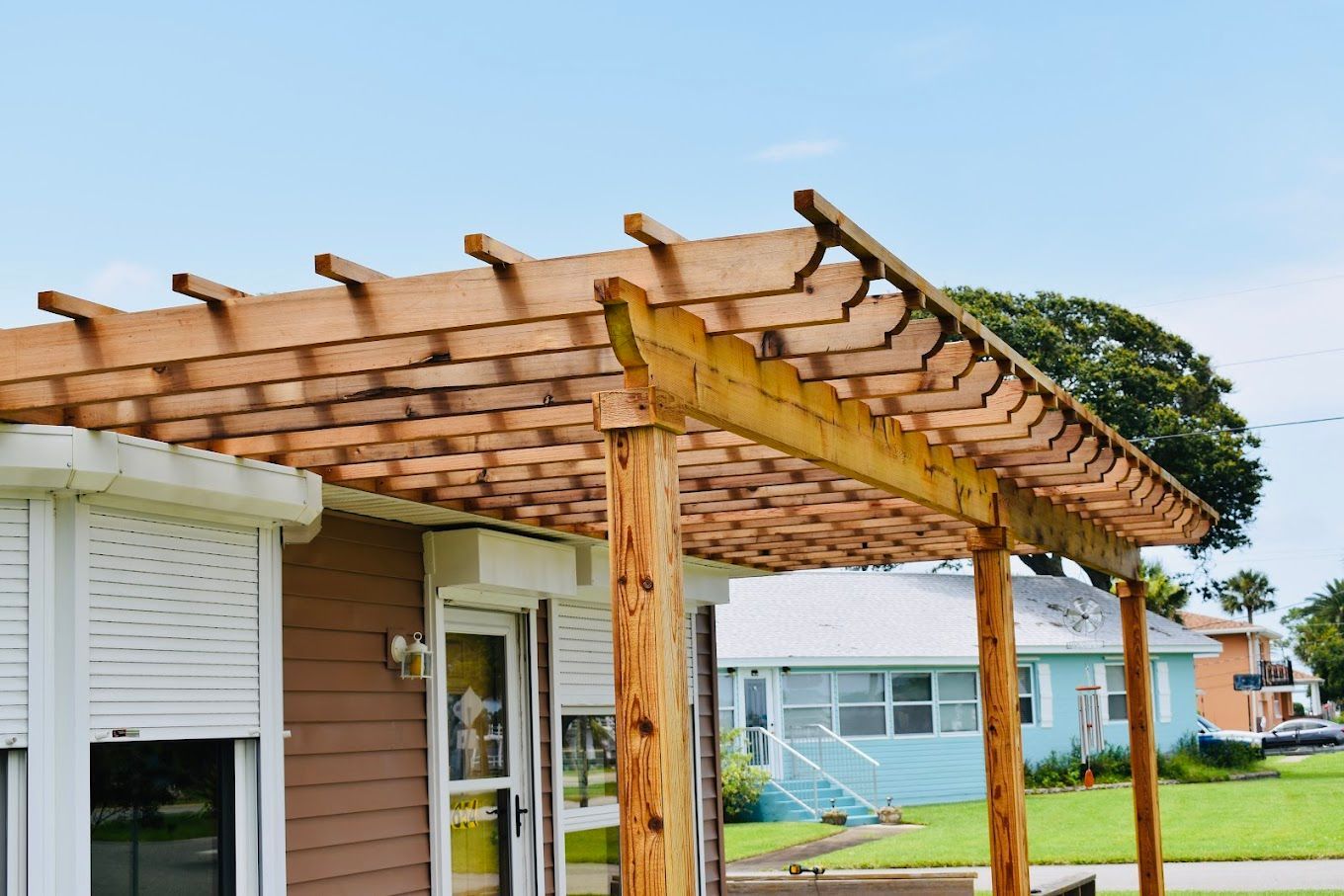 A wooden pergola is sitting on top of a house.