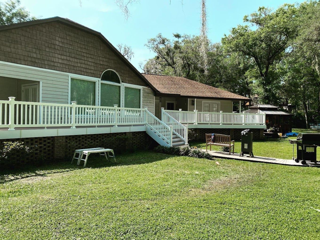 A house with a large deck and stairs in the backyard.