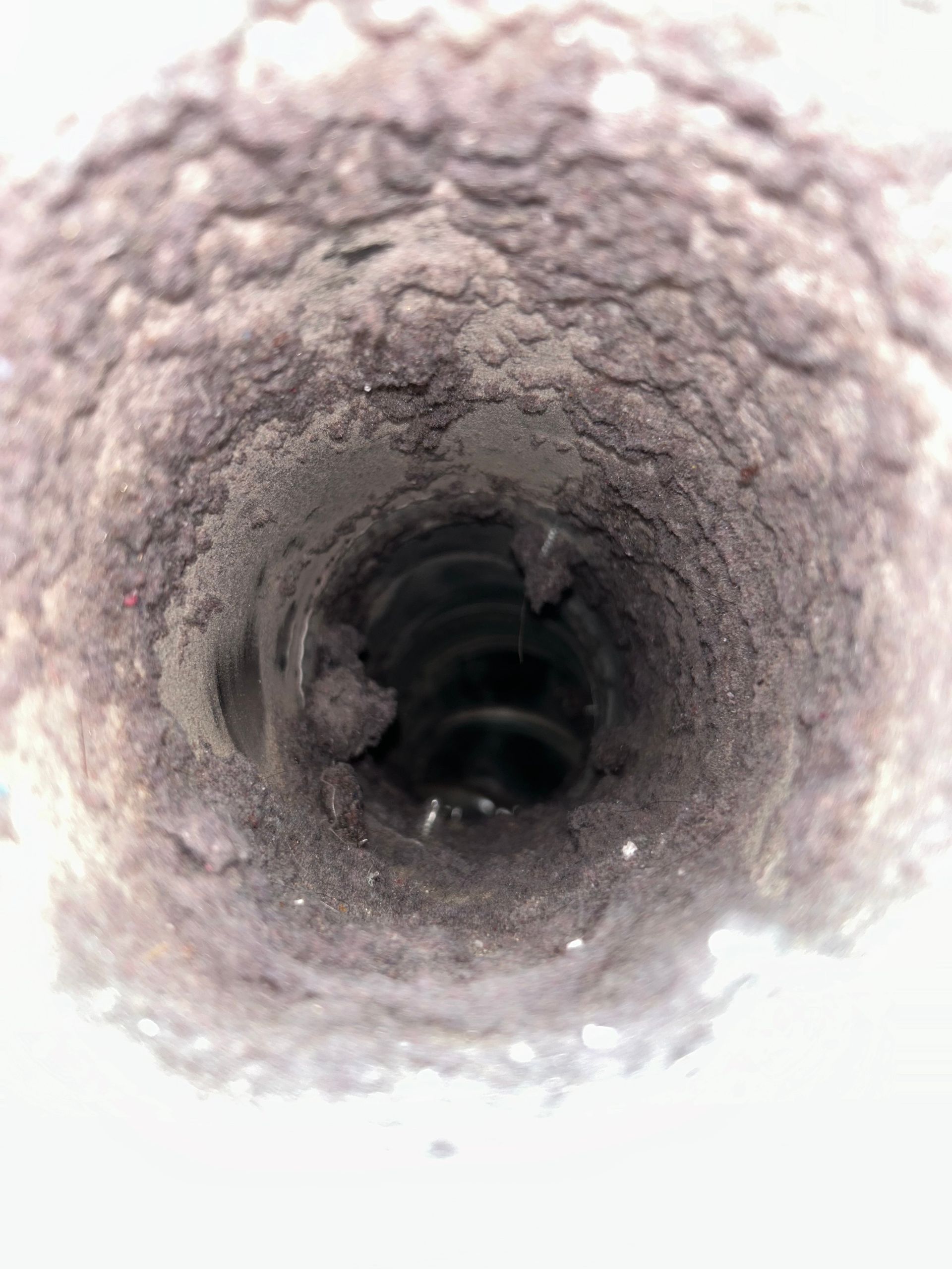 Inside view of a narrow, rough-lined pipe or tunnel with a dark center