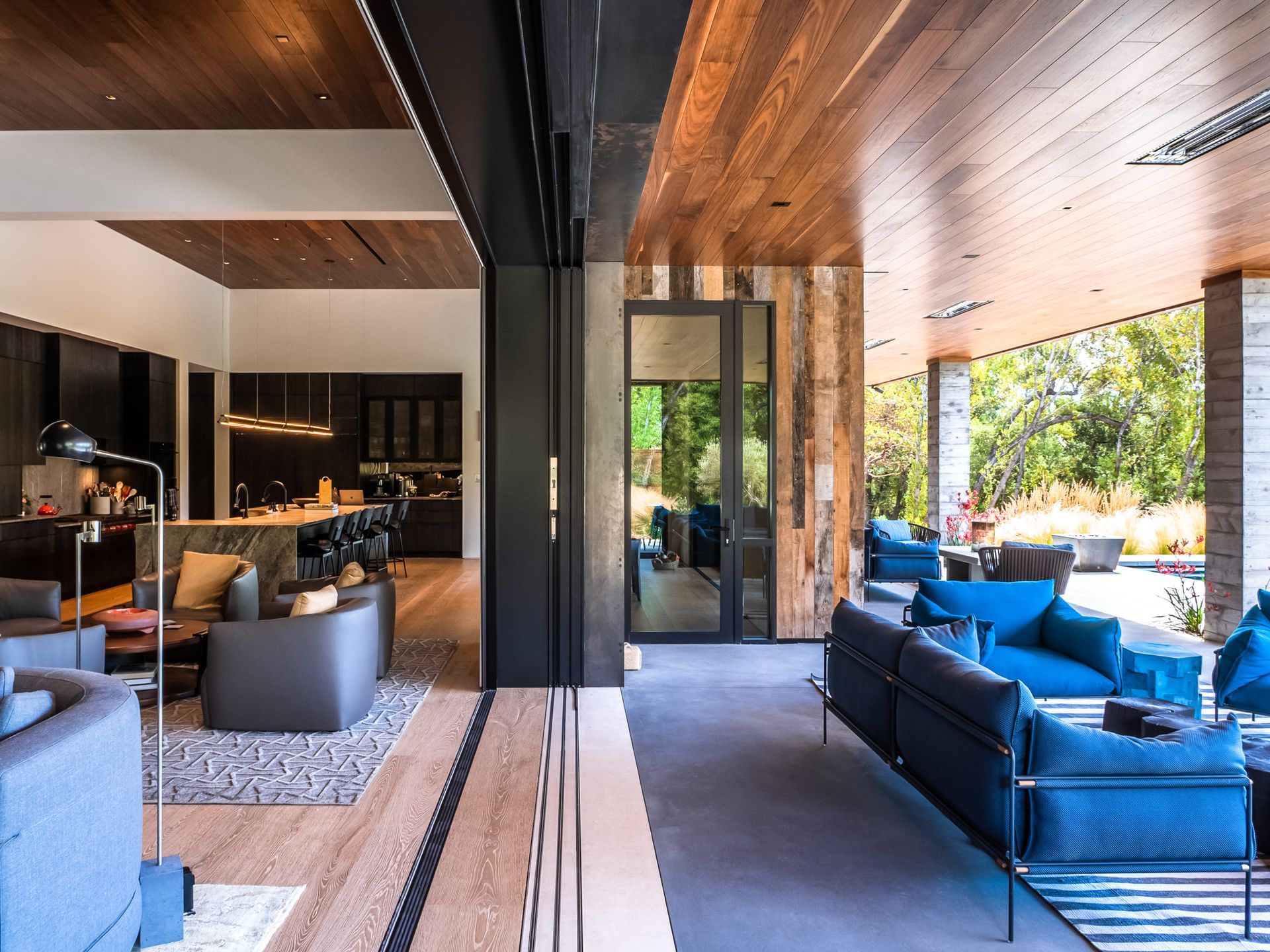 A living room filled with furniture and a sliding glass door leading to a kitchen.