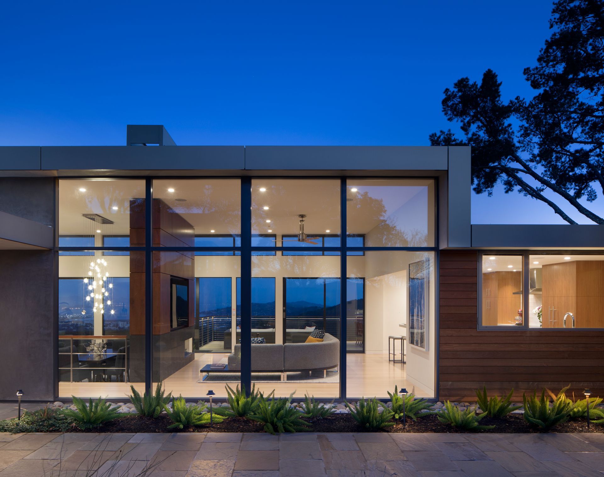 A modern house with a lot of windows and a couch in the living room