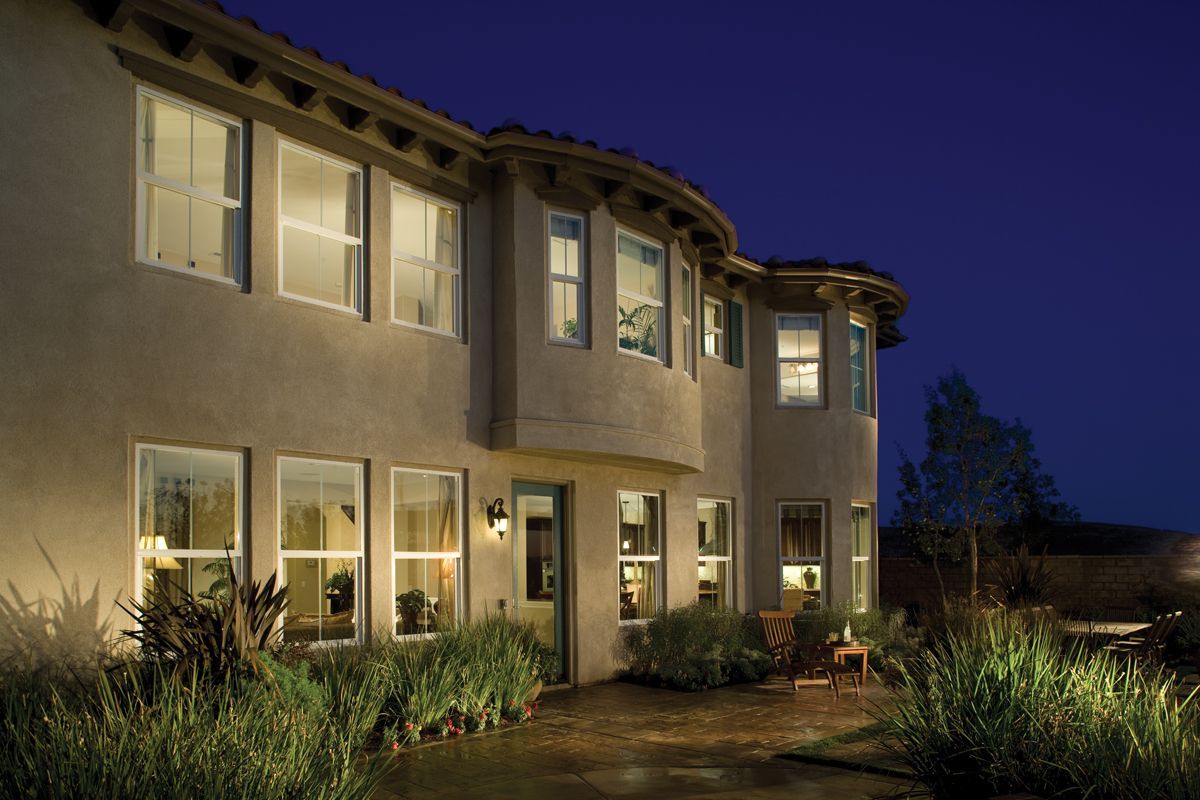 A large house with a lot of windows is lit up at night.