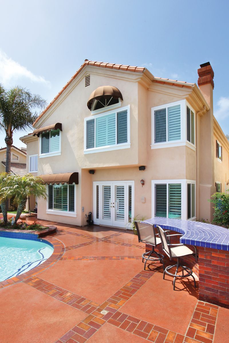 A large house with a swimming pool in front of it