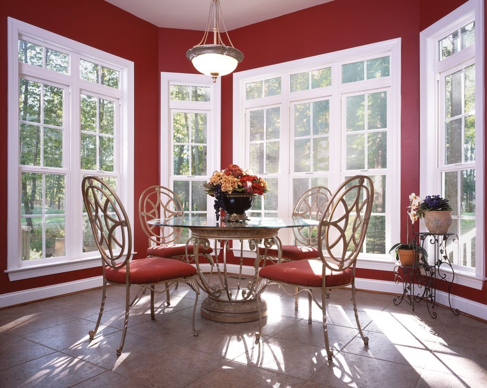A dining room with a table and chairs and red walls